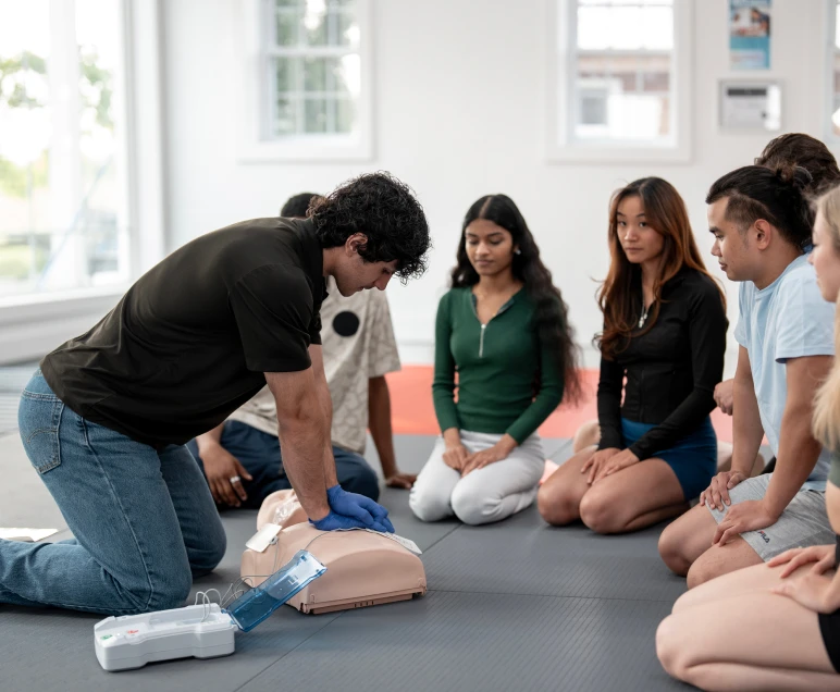 Instructor demonstrating CPR on manikin